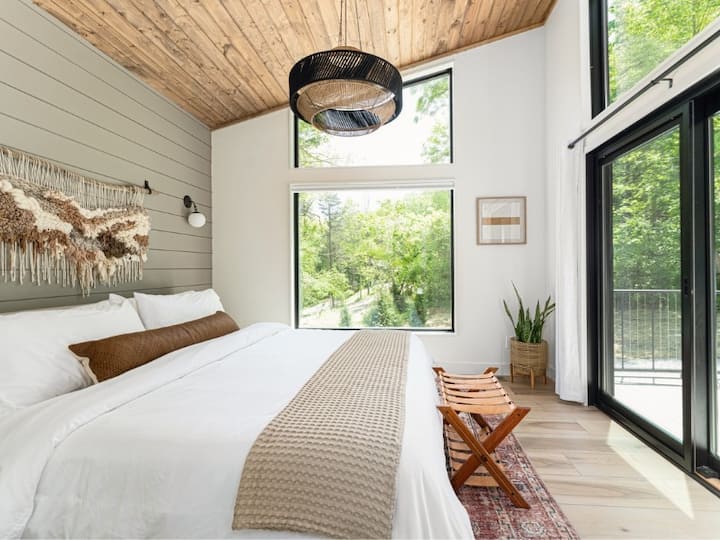 Lush king-size bed with luxury linens + woodland views makes for the perfect bedroom retreat. 