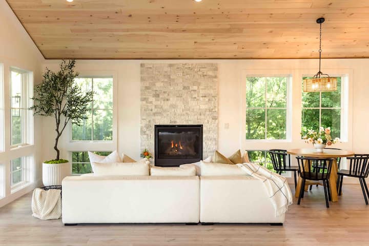 Interior of the living room: modern white couch and indoor propane fireplace with remote